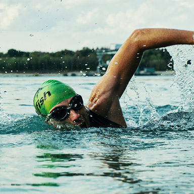 A person swimming in the water wearing goggles.