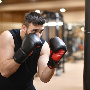 A man wearing boxing gloves in the gym.